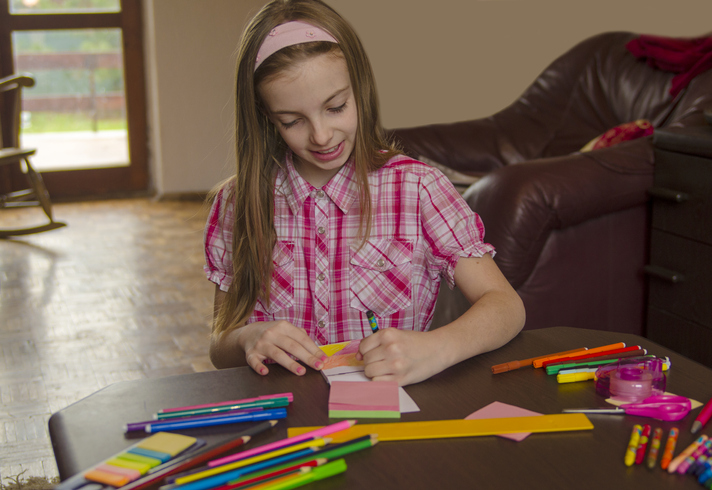 Image of a 10 Year Old Girl Doing Some Drawing at a Table